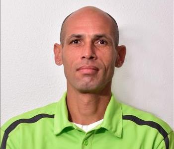 male in green polo with light colored background